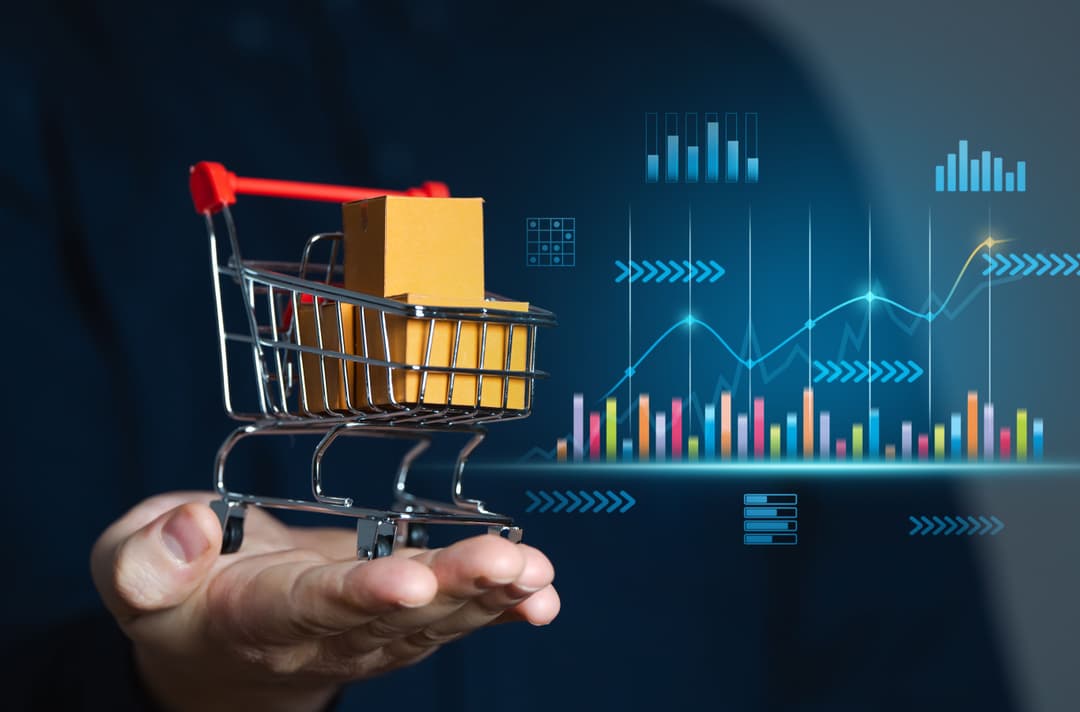 Businessman holding a shopping cart with ecommerce sales and analytics charts